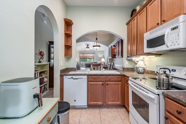 kitchen featuring ceiling fan, hanging light fixtures, light tile patterned floors, white appliances, and sink