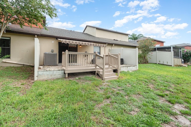 rear view of house with central AC, a lawn, and a wooden deck