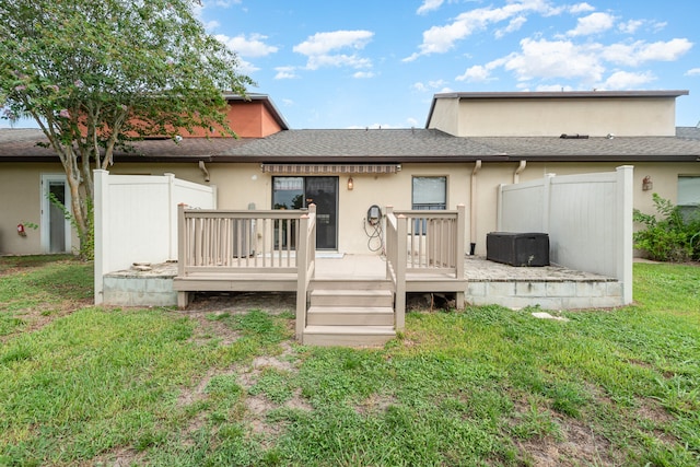 back of house with a deck and a lawn