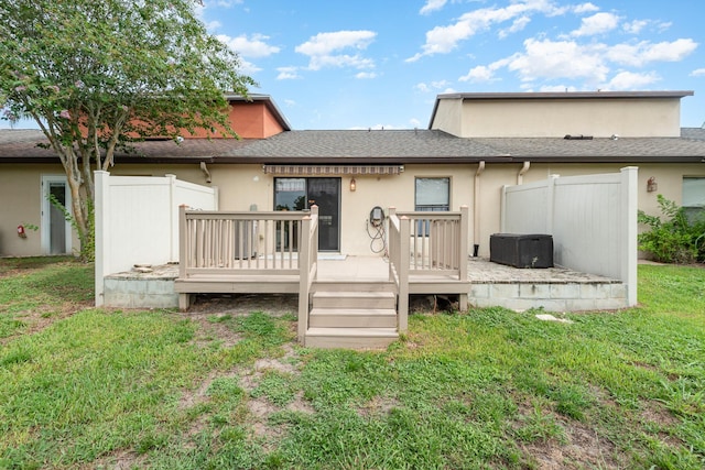 back of property with a yard and a deck