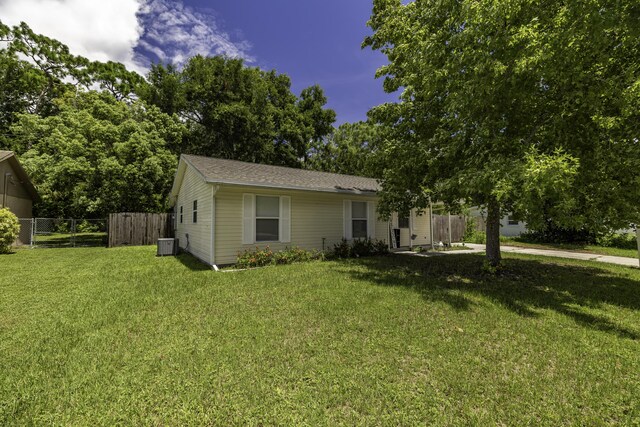 view of front of property with central AC and a front yard