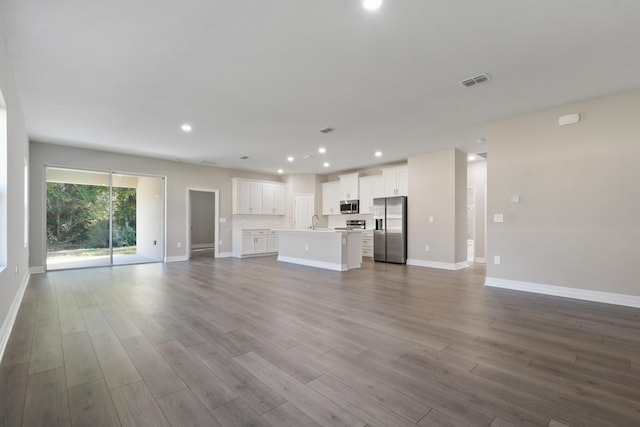 unfurnished living room with sink and light wood-type flooring