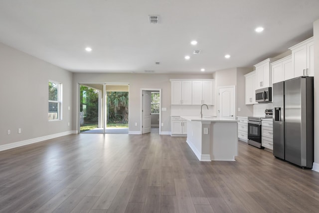 kitchen with appliances with stainless steel finishes, a kitchen island with sink, light hardwood / wood-style flooring, and white cabinets