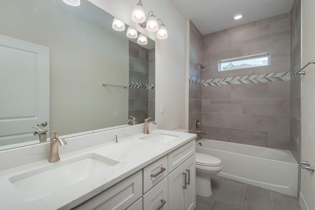 full bathroom featuring tiled shower / bath combo, vanity, tile patterned floors, and toilet