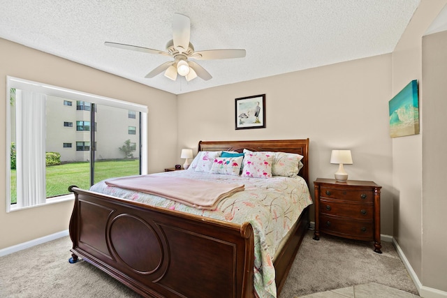 carpeted bedroom with ceiling fan and a textured ceiling