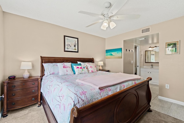 bedroom with sink, light tile patterned floors, ensuite bath, and ceiling fan