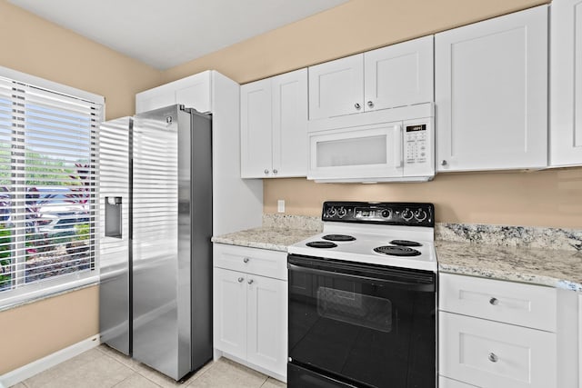 kitchen with electric stove, white cabinetry, stainless steel fridge with ice dispenser, and a wealth of natural light