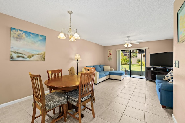 tiled dining room with ceiling fan with notable chandelier and a textured ceiling