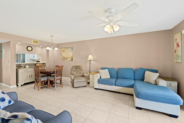 tiled living room featuring ceiling fan with notable chandelier and a textured ceiling