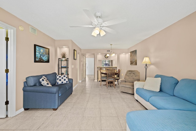 living room with ceiling fan with notable chandelier and light tile patterned floors