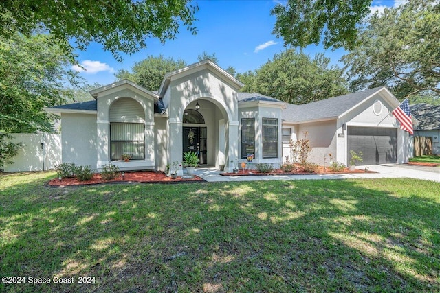 view of front of property with a garage and a front lawn