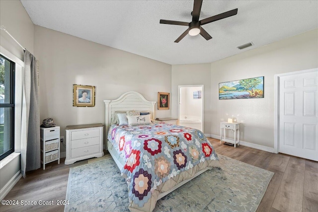 bedroom with hardwood / wood-style floors, ensuite bathroom, a textured ceiling, and ceiling fan