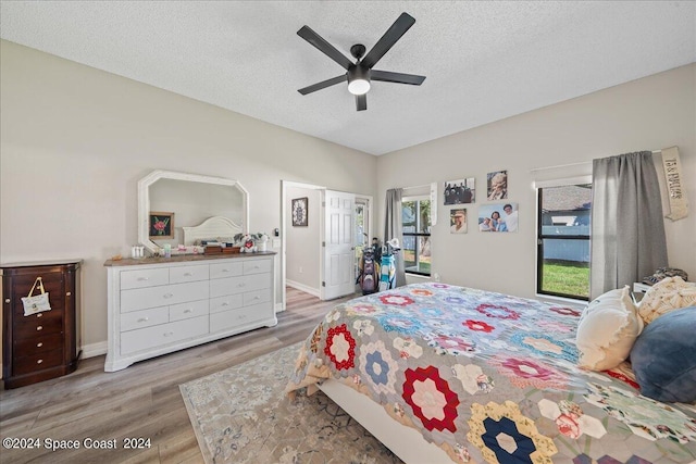 bedroom featuring ceiling fan, wood-type flooring, and a textured ceiling