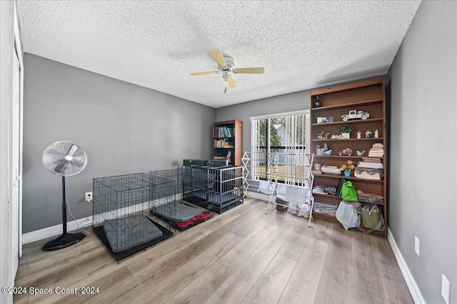 miscellaneous room featuring a textured ceiling, ceiling fan, and light hardwood / wood-style floors