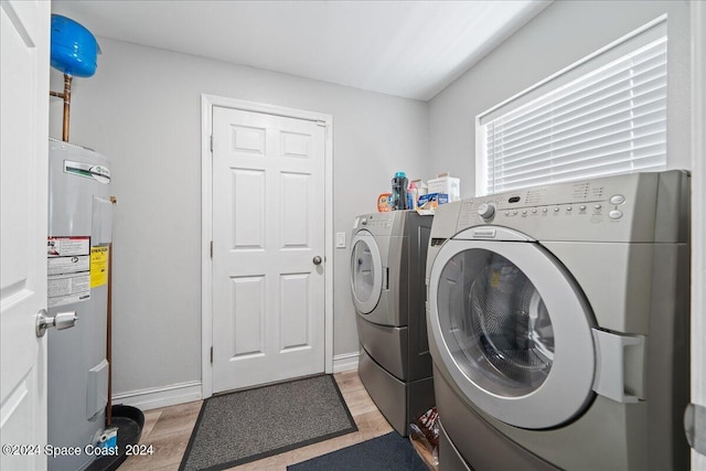 washroom featuring electric water heater, light wood-type flooring, and washer and clothes dryer