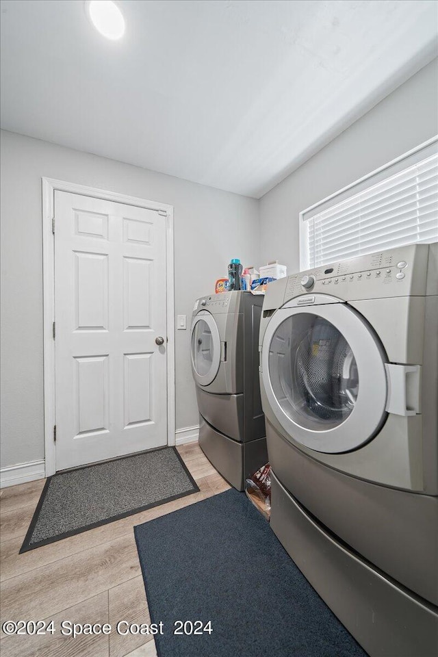 laundry room with light hardwood / wood-style floors and washer and dryer