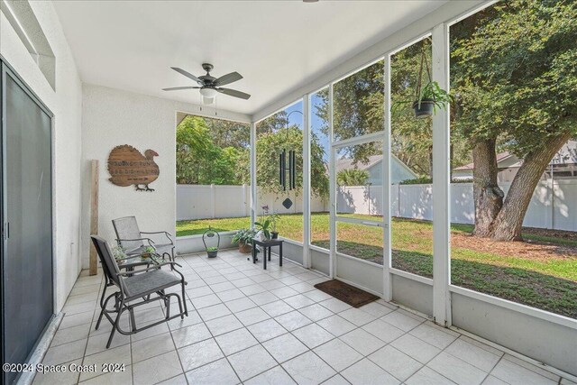 unfurnished sunroom featuring ceiling fan