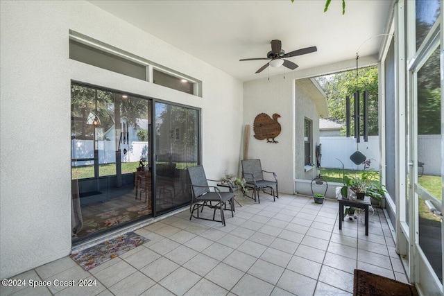 unfurnished sunroom with ceiling fan