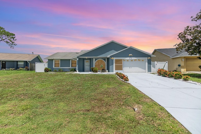 ranch-style home with a garage and a yard