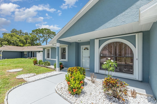 view of exterior entry with a yard