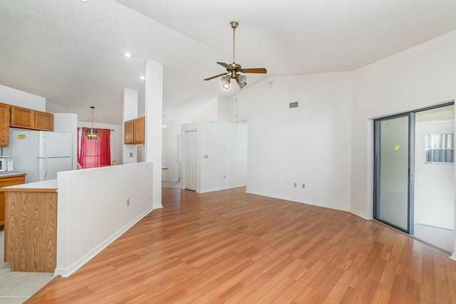 kitchen with white appliances, high vaulted ceiling, ceiling fan, and light wood-type flooring