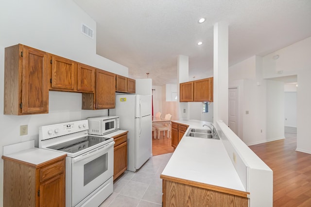 kitchen with white appliances, sink, and light tile patterned floors