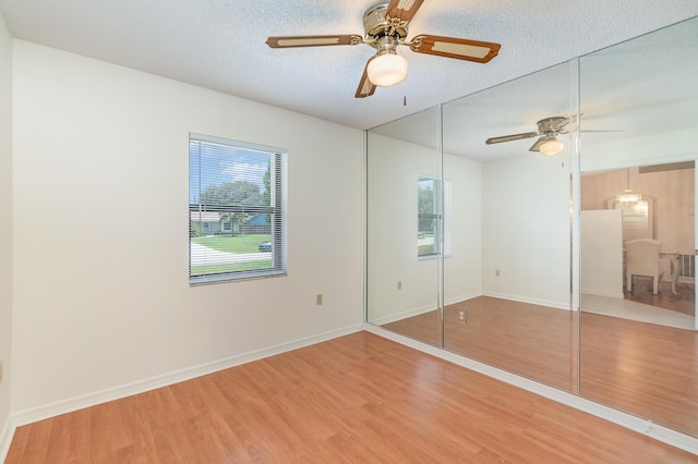 unfurnished bedroom featuring ceiling fan, hardwood / wood-style flooring, a closet, and a textured ceiling