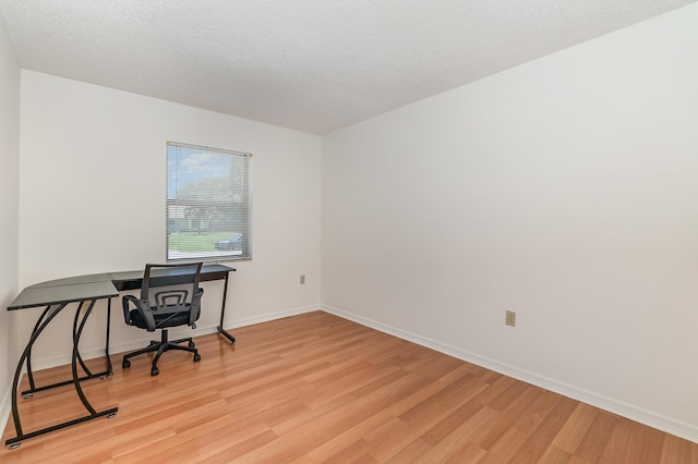 home office featuring a textured ceiling and light wood-type flooring