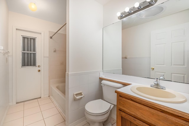 full bathroom featuring tile patterned floors, toilet, tile walls, vanity, and tiled shower / bath combo