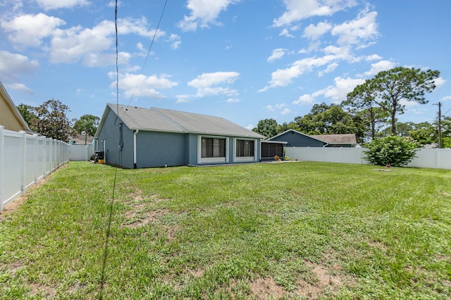 back of house with a lawn