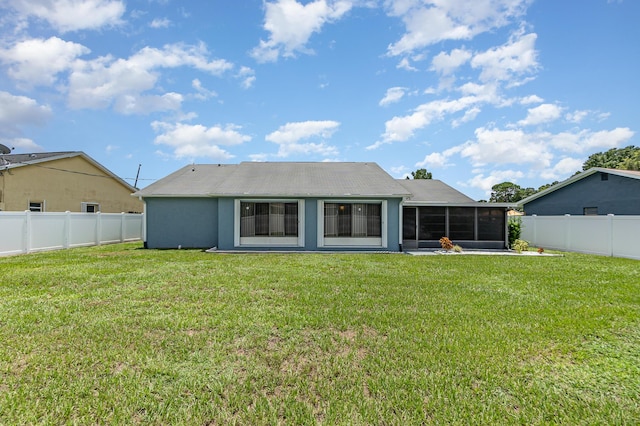 back of house with a lawn and a sunroom