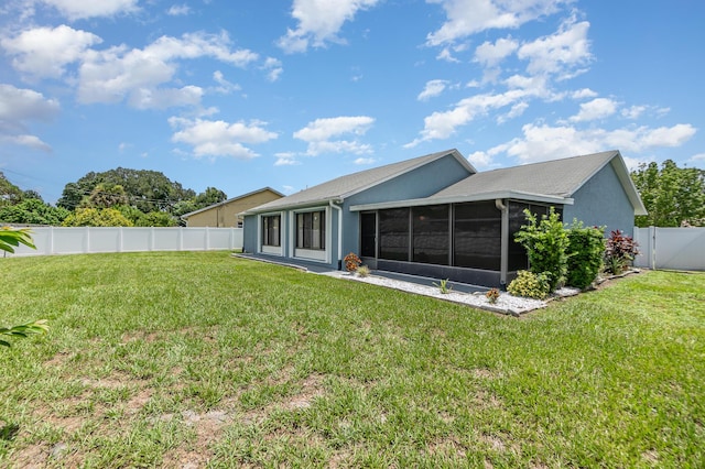 rear view of property with a sunroom and a lawn