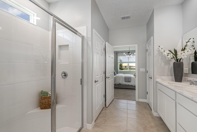 bathroom featuring tile patterned floors, a shower with shower door, an inviting chandelier, a textured ceiling, and vanity