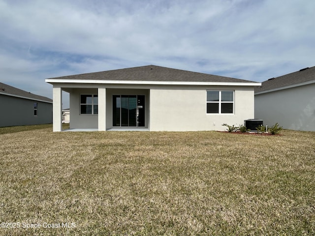 back of property with a patio, central AC, and a lawn