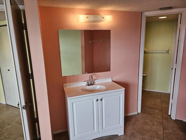 bathroom with vanity, tile patterned floors, and a textured ceiling