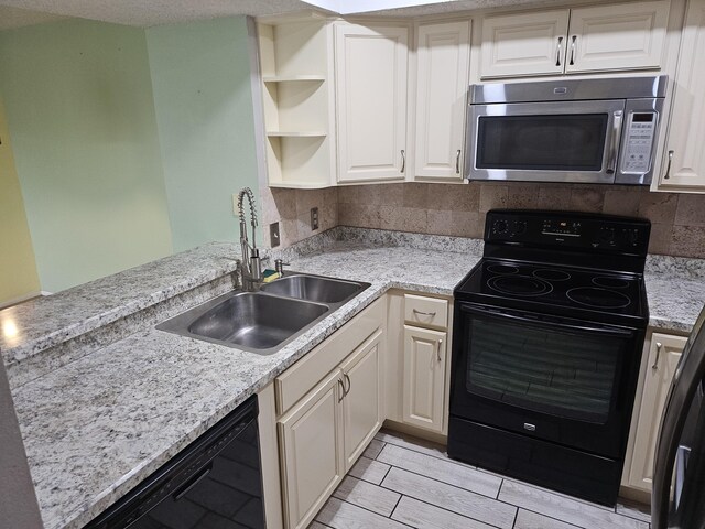 kitchen with sink, tasteful backsplash, kitchen peninsula, light stone countertops, and black appliances