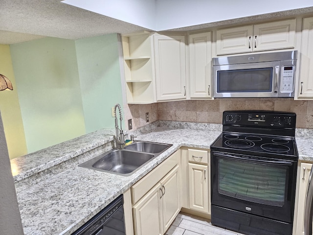 kitchen featuring sink, kitchen peninsula, decorative backsplash, and black appliances