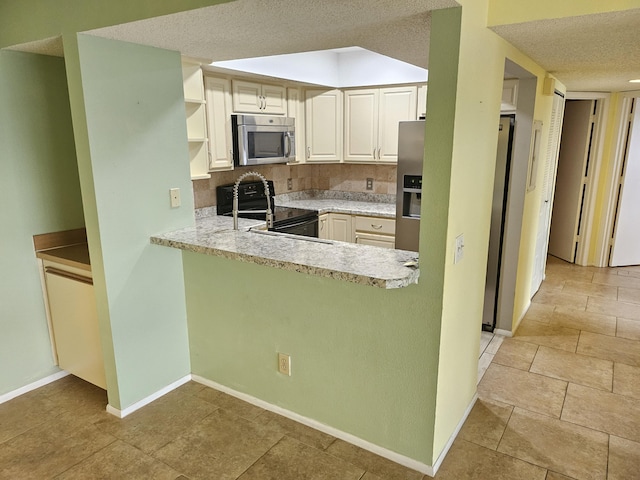 kitchen with stainless steel appliances, kitchen peninsula, a textured ceiling, and decorative backsplash