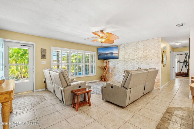 tiled living room featuring ceiling fan and a textured ceiling