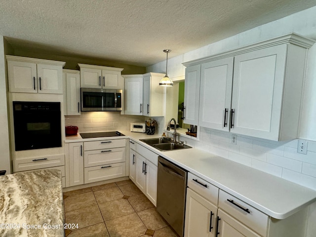 kitchen with hanging light fixtures, white cabinetry, tasteful backsplash, black appliances, and sink