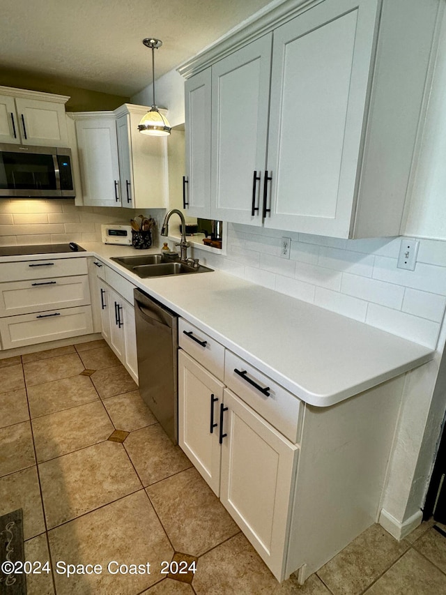 kitchen featuring white cabinets, appliances with stainless steel finishes, hanging light fixtures, and sink