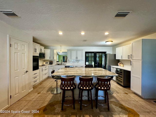 kitchen featuring white cabinets, stainless steel appliances, sink, and a center island