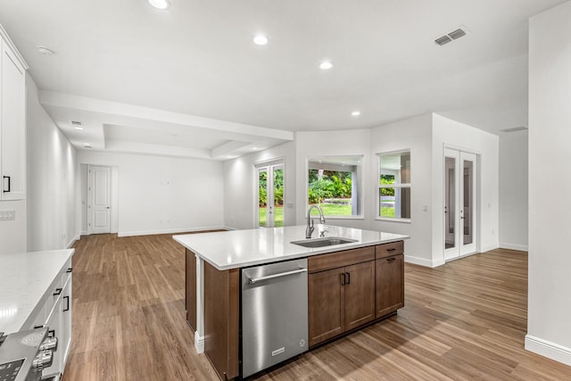 kitchen featuring light hardwood / wood-style floors, an island with sink, sink, and stainless steel dishwasher