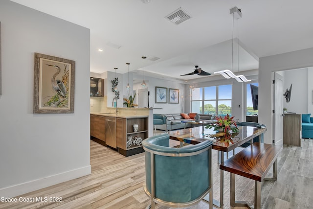 kitchen with a sink, visible vents, stainless steel dishwasher, and light wood finished floors