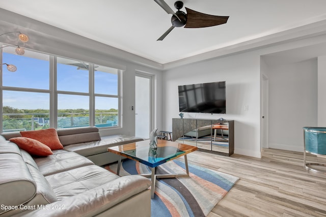 living room featuring a ceiling fan, baseboards, and wood finished floors