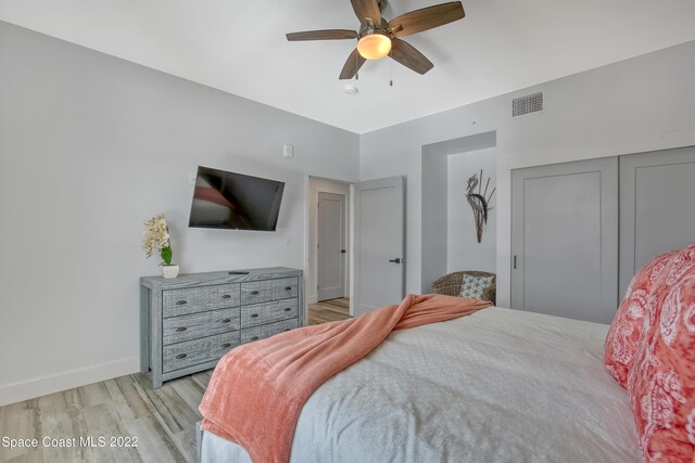 bedroom featuring light hardwood / wood-style flooring, a closet, and ceiling fan