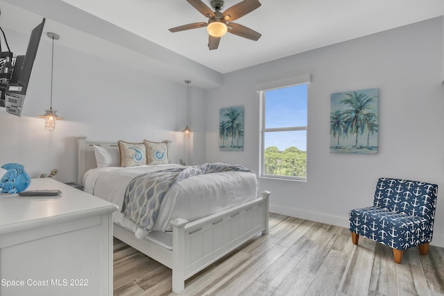 bedroom with baseboards, ceiling fan, and light wood-type flooring