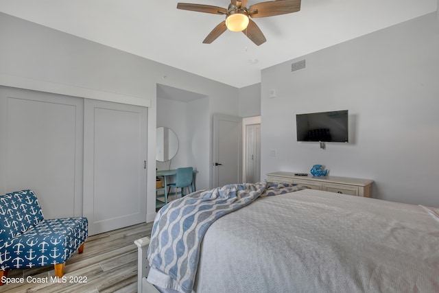 bedroom with visible vents, a closet, light wood-type flooring, and a ceiling fan