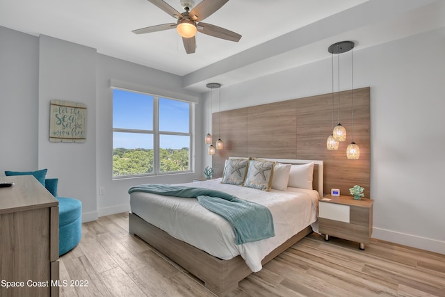 bedroom with baseboards, ceiling fan, and light wood-type flooring