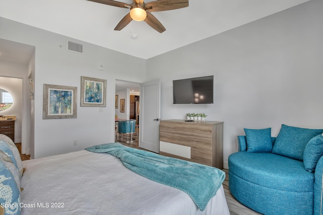 bedroom with ceiling fan, light wood finished floors, and visible vents
